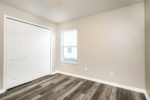2216 Heathwood Cir, Orlando, FL 32828 - unfurnished bedroom with dark wood-style flooring, a closet, baseboards, and a textured ceiling