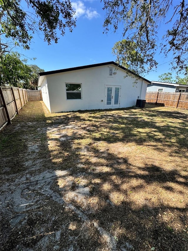 1778 New Hampshire Ave NE, Saint Petersburg, FL 33703 - rear view of house featuring french doors, stucco siding, a fenced backyard, and central AC unit