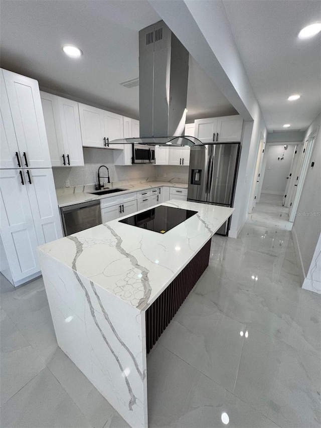 1778 New Hampshire Ave NE, Saint Petersburg, FL 33703 - kitchen with stainless steel appliances, a sink, white cabinetry, a center island, and light stone countertops