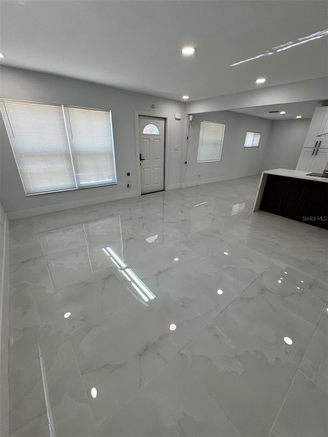 1778 New Hampshire Ave NE, Saint Petersburg, FL 33703 - unfurnished living room featuring light marble finish floors and recessed lighting