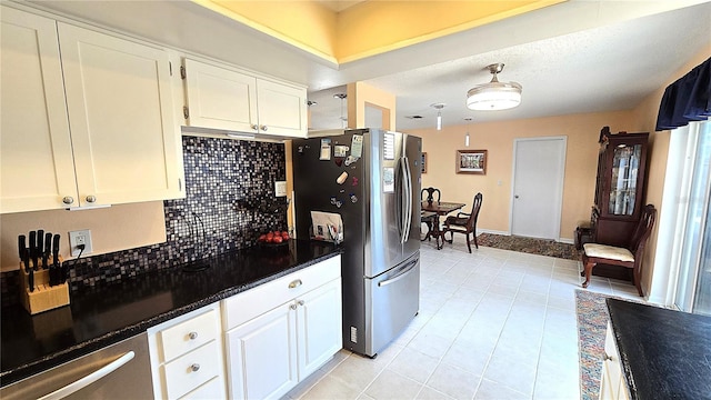 3907 Orchard Hill Cir, Palm Harbor, FL 34684 - kitchen featuring freestanding refrigerator, decorative backsplash, white cabinets, dark countertops, and light tile patterned floors