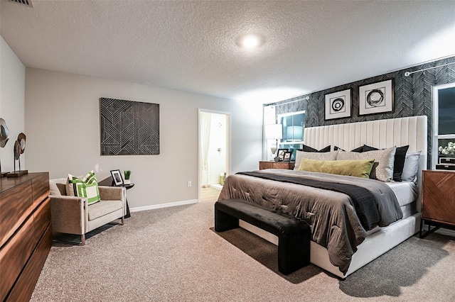 bedroom with carpet flooring, a textured ceiling, baseboards, and ensuite bathroom