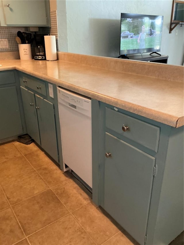 kitchen with white dishwasher, decorative backsplash, light tile patterned flooring, and light countertops