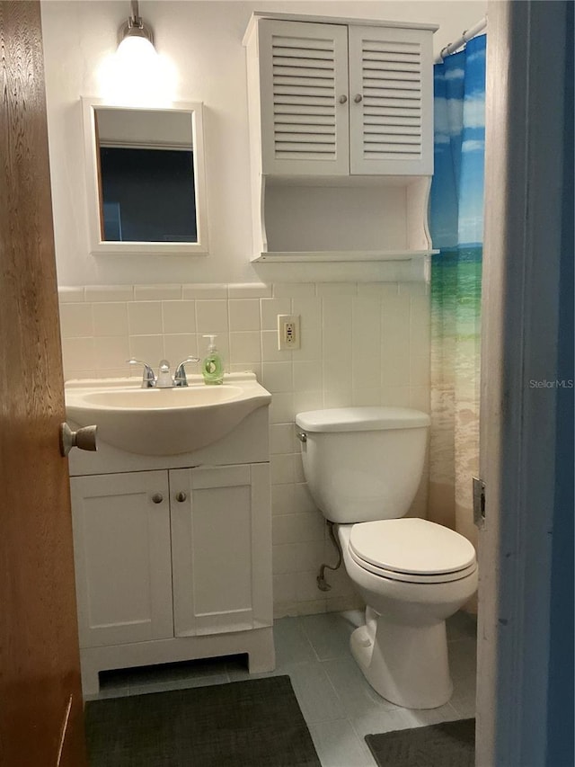 full bath featuring toilet, vanity, and tile patterned floors