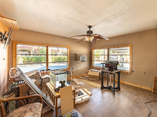 6726 Udell Ln, Hudson, FL 34667 - interior space featuring ceiling fan, wood finished floors, an AC wall unit, baseboards, and a textured ceiling