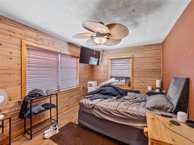 6726 Udell Ln, Hudson, FL 34667 - bedroom featuring wood walls, wood finished floors, a textured ceiling, a ceiling fan, and cooling unit