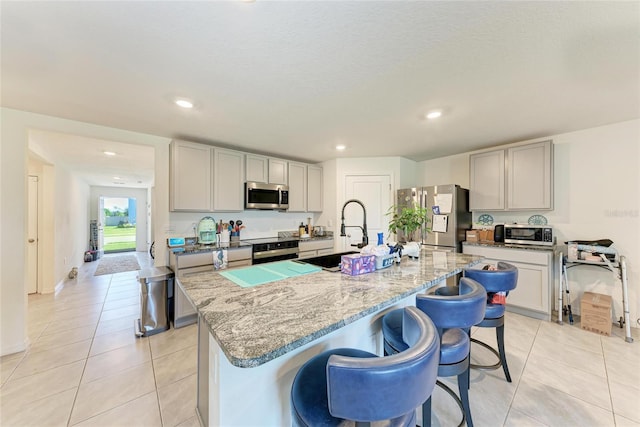 10732 Chippewa Dr, Parrish, FL 34219 - kitchen with stainless steel appliances, a sink, light stone counters, light tile patterned flooring, and recessed lighting