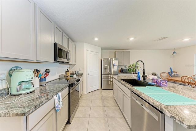 10732 Chippewa Dr, Parrish, FL 34219 - kitchen featuring stainless steel appliances, a sink, light tile patterned floors, recessed lighting, and light stone countertops