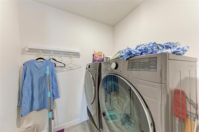 10732 Chippewa Dr, Parrish, FL 34219 - clothes washing area featuring washer and clothes dryer, baseboards, and light tile patterned flooring