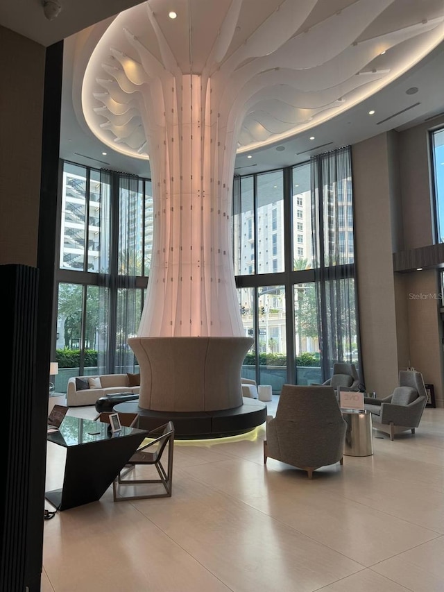building lobby featuring expansive windows, a towering ceiling, and recessed lighting