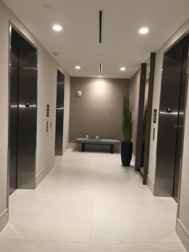 hallway featuring elevator, recessed lighting, and baseboards