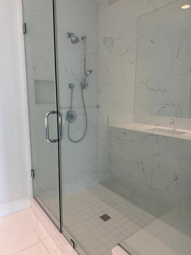 bathroom with marble finish flooring and a marble finish shower