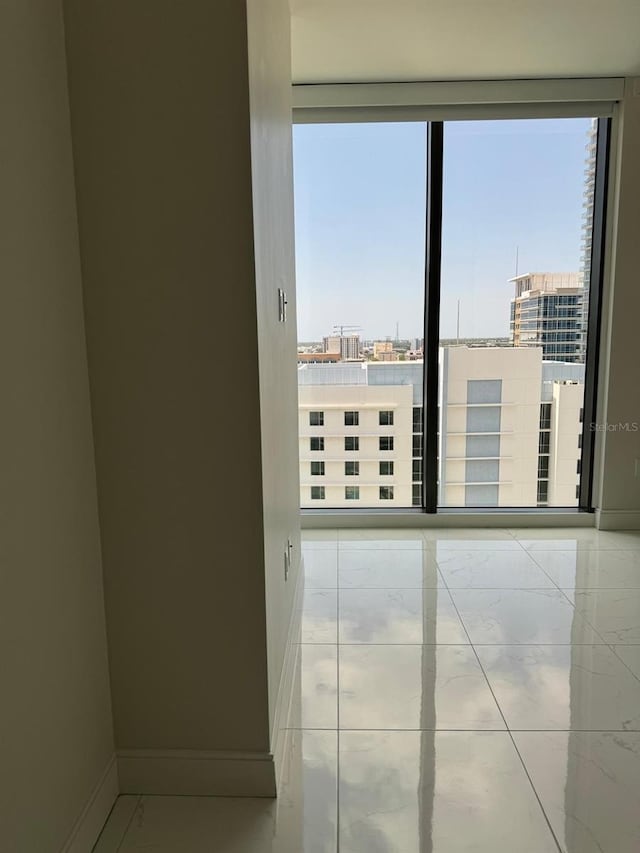 unfurnished room with baseboards and a view of city
