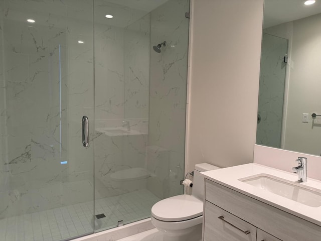 bathroom with toilet, a marble finish shower, vanity, and recessed lighting
