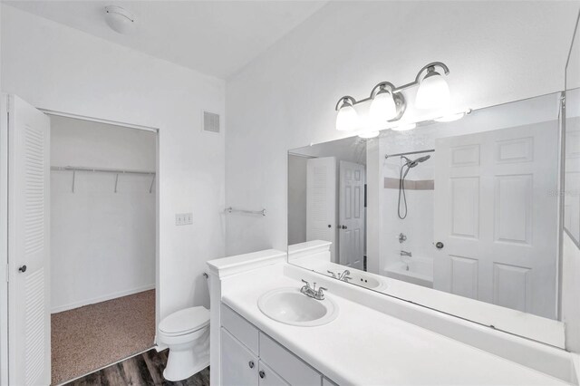 9602 Lake Chase Island Way Unit 9602, Tampa, FL 33626 - full bath featuring vanity, washtub / shower combination, wood finished floors, toilet, and a walk in closet