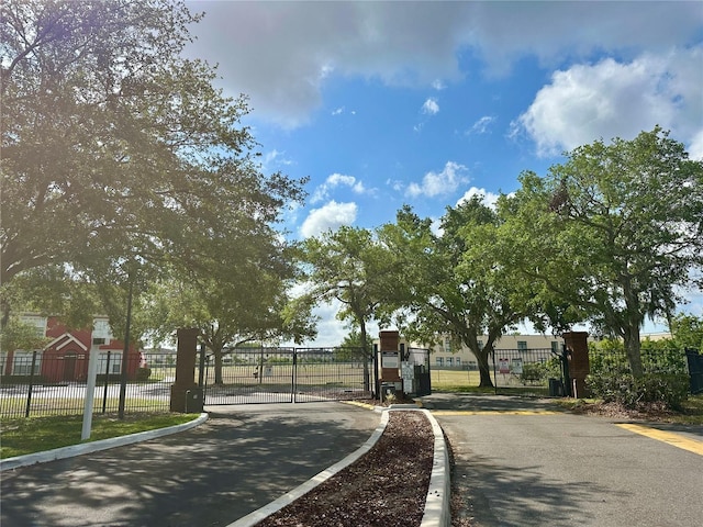 9602 Lake Chase Island Way Unit 9602, Tampa, FL 33626 - view of asphalt street featuring a gate, curbs, and a gated entry