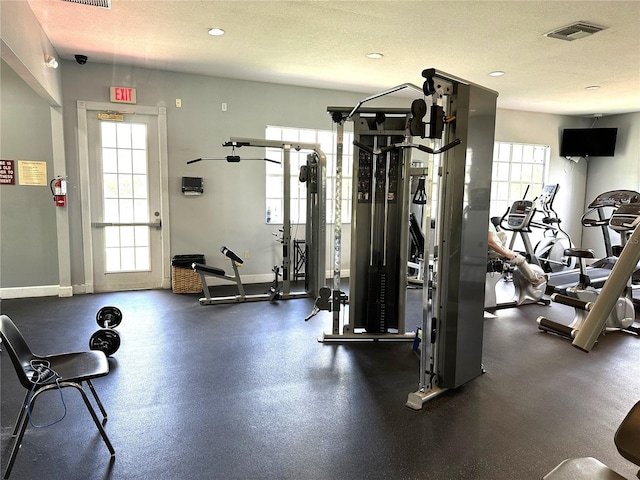 9602 Lake Chase Island Way Unit 9602, Tampa, FL 33626 - exercise room featuring a textured ceiling, baseboards, and recessed lighting