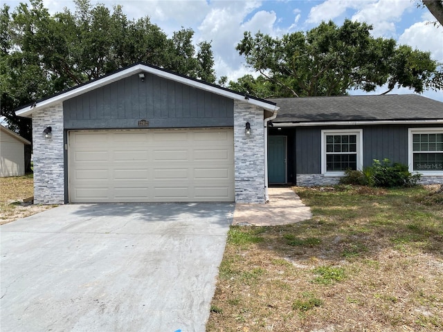 12912 Leadwood Dr, Riverview, FL 33579 - ranch-style house with stone siding, concrete driveway, an attached garage, and a shingled roof