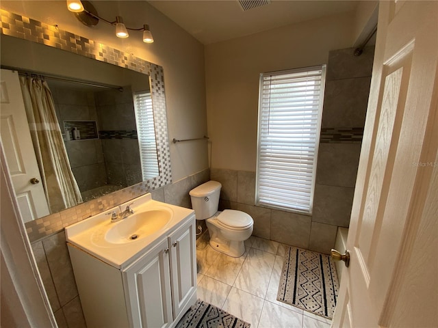 12912 Leadwood Dr, Riverview, FL 33579 - bathroom featuring tile walls, a tile shower, vanity, and toilet