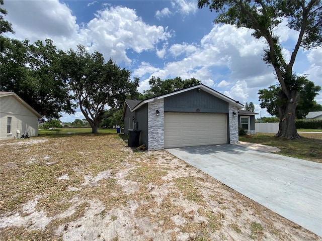 12912 Leadwood Dr, Riverview, FL 33579 - view of side of property featuring driveway, a garage, and stone siding