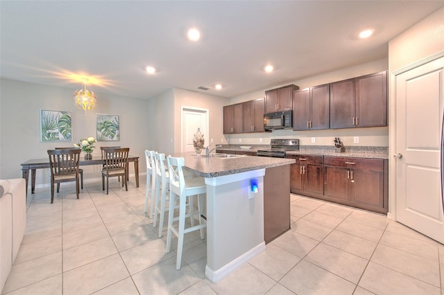 10210 White Linen Ave, Riverview, FL 33578 - kitchen with black microwave, stainless steel electric range, light tile patterned floors, dark brown cabinets, and recessed lighting