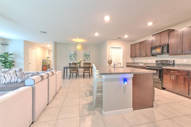 10210 White Linen Ave, Riverview, FL 33578 - kitchen with electric stove, black microwave, open floor plan, light tile patterned flooring, and an island with sink