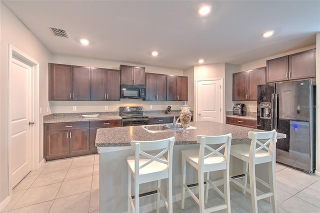 10210 White Linen Ave, Riverview, FL 33578 - kitchen featuring black appliances, light tile patterned floors, a kitchen island with sink, a breakfast bar area, and recessed lighting