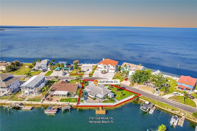 aerial perspective of suburban area with a nearby body of water and property boundaries highlighted