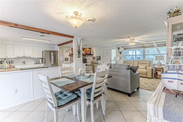 dining room featuring light tile patterned floors, a ceiling fan, and a textured ceiling