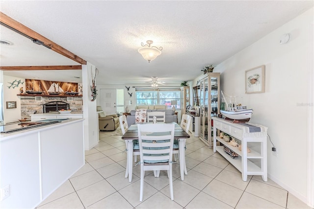 dining space featuring ceiling fan, light tile patterned floors, and a textured ceiling