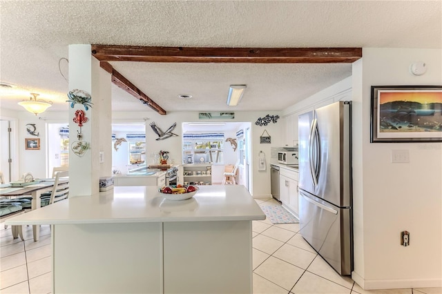 kitchen featuring stainless steel appliances, white cabinetry, light countertops, light tile patterned floors, and a textured ceiling