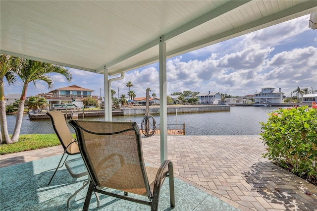 view of patio / terrace featuring a water view, a residential view, and a boat dock