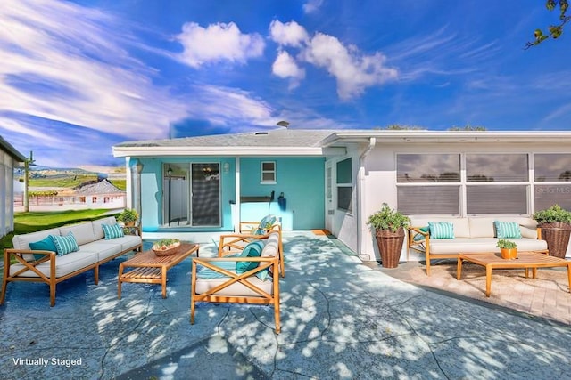 back of property with an outdoor living space, a patio area, and stucco siding