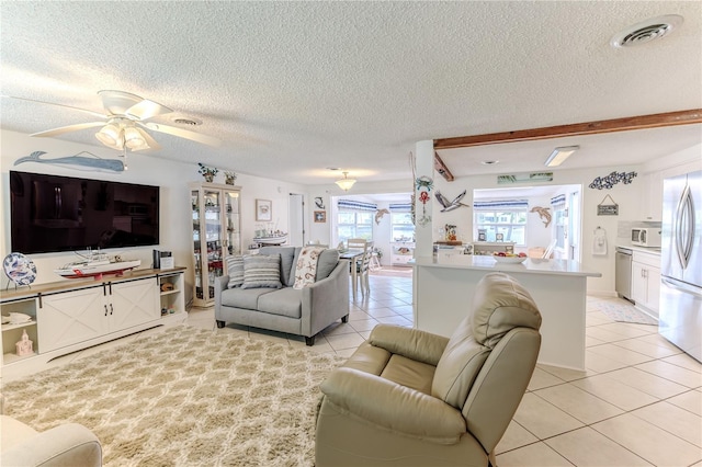 living room with light tile patterned floors, a textured ceiling, and ceiling fan