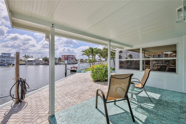 view of patio featuring a water view and a boat dock