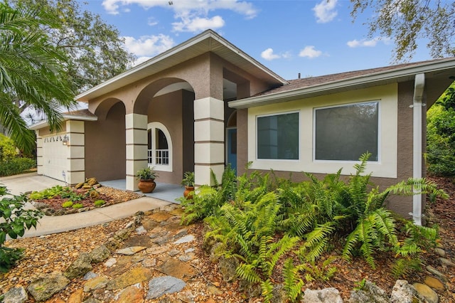 160 Sage Cir, Crystal Beach, FL 34681 - doorway to property featuring stucco siding, a garage, and concrete driveway