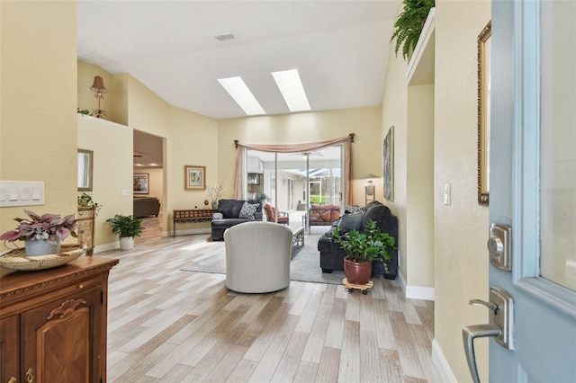 160 Sage Cir, Crystal Beach, FL 34681 - living room with a skylight, light wood-style floors, vaulted ceiling, and baseboards