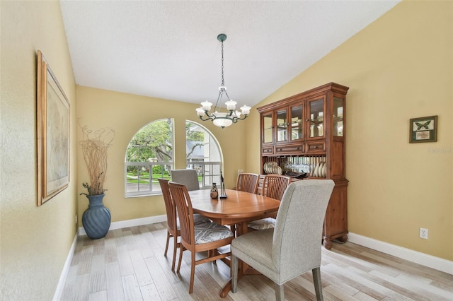 160 Sage Cir, Crystal Beach, FL 34681 - dining space with light wood-style flooring, a chandelier, lofted ceiling, and baseboards