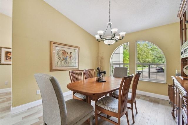 160 Sage Cir, Crystal Beach, FL 34681 - dining area featuring a chandelier, baseboards, light wood-type flooring, and lofted ceiling