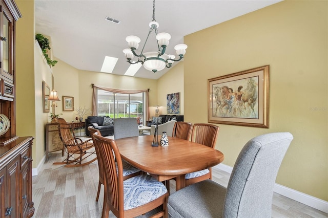 160 Sage Cir, Crystal Beach, FL 34681 - dining space featuring a chandelier, light wood-style floors, baseboards, and a skylight