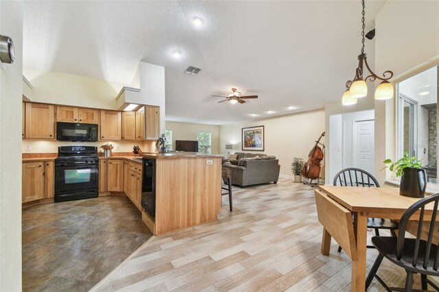 160 Sage Cir, Crystal Beach, FL 34681 - kitchen with black appliances, a peninsula, open floor plan, a breakfast bar, and a ceiling fan