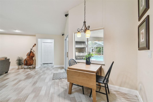 160 Sage Cir, Crystal Beach, FL 34681 - dining room featuring a chandelier, baseboards, light wood-type flooring, and high vaulted ceiling