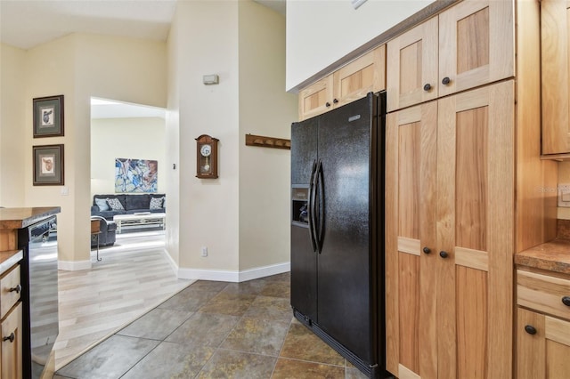 160 Sage Cir, Crystal Beach, FL 34681 - kitchen featuring black fridge with ice dispenser, light brown cabinets, baseboards, and stainless steel dishwasher