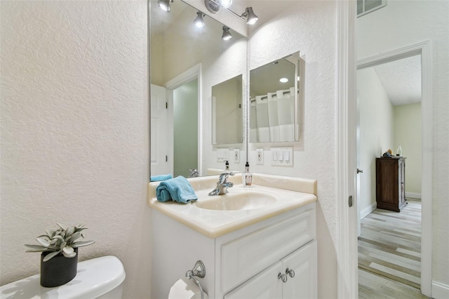 160 Sage Cir, Crystal Beach, FL 34681 - full bath with a textured wall, vanity, wood finished floors, and toilet