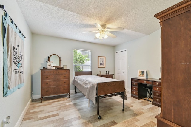 160 Sage Cir, Crystal Beach, FL 34681 - bedroom featuring light wood-style floors, a textured ceiling, an office area, ceiling fan, and a closet