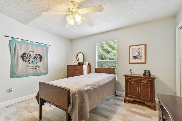 160 Sage Cir, Crystal Beach, FL 34681 - bedroom with light wood-style flooring, a textured ceiling, baseboards, and a ceiling fan