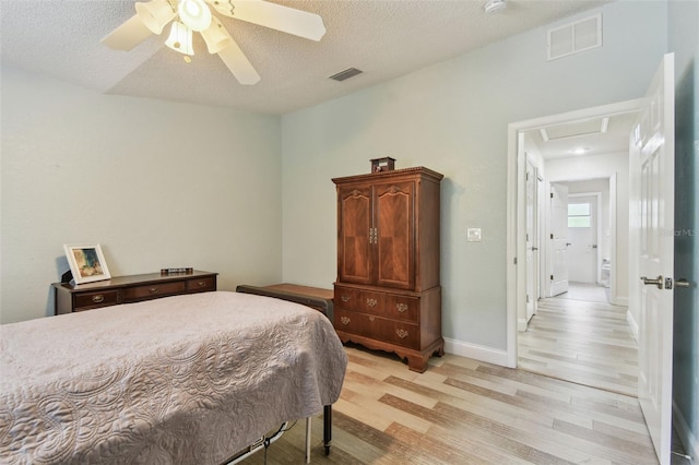 160 Sage Cir, Crystal Beach, FL 34681 - bedroom featuring light wood finished floors, a textured ceiling, ceiling fan, and baseboards