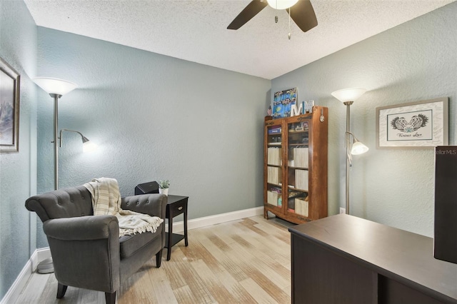 160 Sage Cir, Crystal Beach, FL 34681 - sitting room with light wood-style flooring, a textured wall, ceiling fan, a textured ceiling, and baseboards