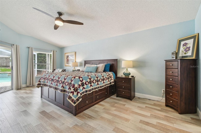 160 Sage Cir, Crystal Beach, FL 34681 - bedroom featuring lofted ceiling, light wood-style floors, access to outside, a textured ceiling, and baseboards