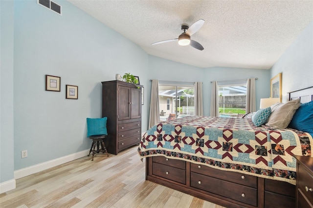 160 Sage Cir, Crystal Beach, FL 34681 - bedroom with vaulted ceiling, a textured ceiling, light wood finished floors, access to exterior, and ceiling fan